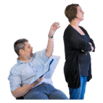 A disabled person holding paperwork trying to get the attention of another person, who has their back towards them and is ignoring them.